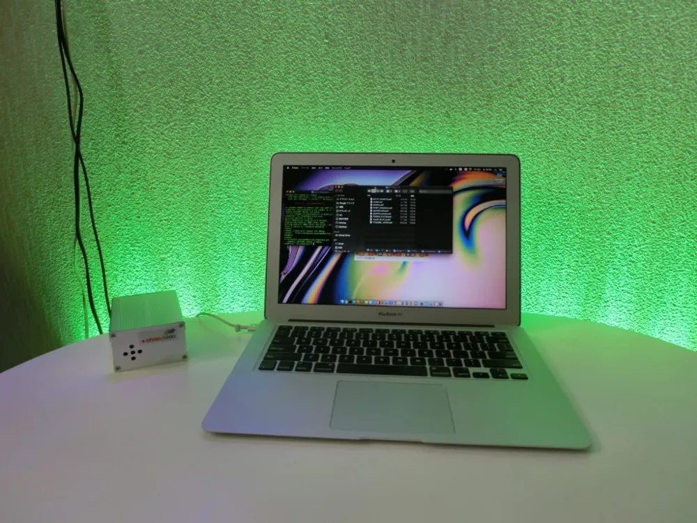 co2.chameleon controlling green lighting beside a laptop